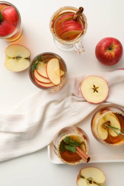 Elma şırası ve beyaz arka planda elmalı bardaklar.