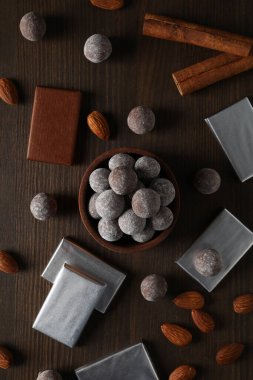 Çikolata topları, çikolatalar ve bademlerle ahşap bir kasede.