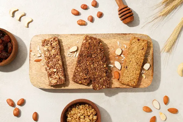 Tahta bir tahtanın üzerinde mısır ve fındık kulaklı granola çubukları.