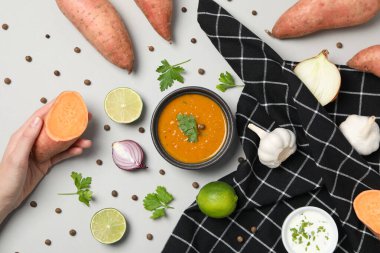 Havluda tatlı patates püresi, malzemeler ve beyaz arka planda el.