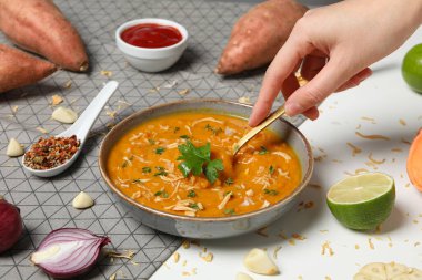 Havluda tatlı patates püresi, içindekiler ve beyaz arka planda kaşık.