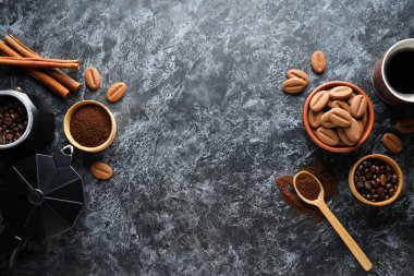 Koyu arkaplanda kurabiyeler olan bir fincan kahve.