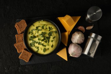 Siyah arka planda otlu peynir çorbası.