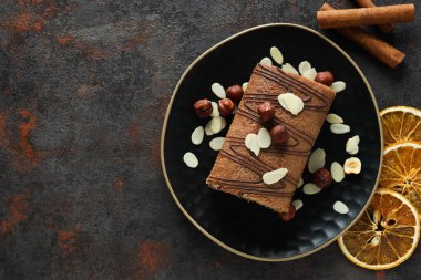 Koyu arkaplanda kurutulmuş portakallı bir kasede kek yuvarla.