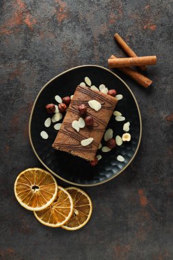 Koyu arkaplanda kurutulmuş portakallı bir kasede kek yuvarla.