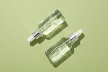 Yeşil arka planda şeffaf kozmetik şişeleri