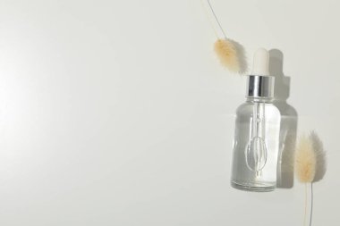 Kurumuş çiçeklerle dolu bir şişede kozmetik yağı