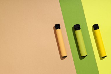 Hafif arka planda üç elektronik sigara.