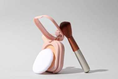 Hafif bir arka planda, fırçayla birlikte yüz pudrası.