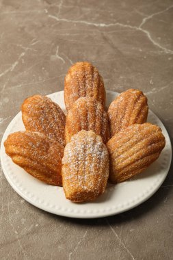 Madeleine pastaları gri arka planda tabakta, kapat