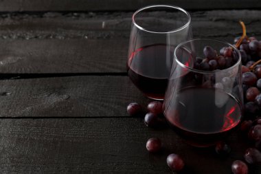 İki kadeh kırmızı şarap, koyu arkaplanda..