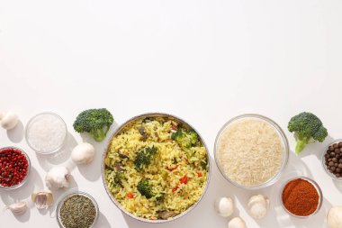 Pilaf, pilav, kâselerde baharatlar ve beyaz arka planda sebzeler, metin için yer