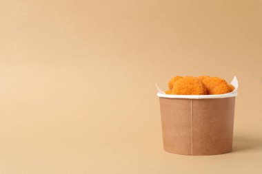 Bej arka planda karton bir kutuda kızarmış mozzarella.