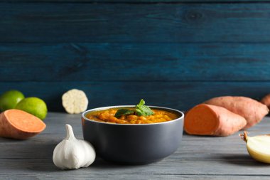 Tatlı patates püresi kasede ve ahşap arka planda malzemeler, metin için yer var.