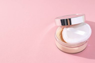 Bir şişe toz, açık renk, pembe arka planda..