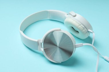 Beyaz, kulaklıklı, mavi arka planda dinleme cihazı olan..