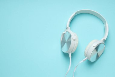 Beyaz, kulaklıklı, mavi arka planda dinleme cihazı olan..