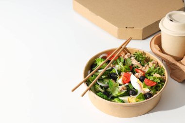 Işık masasındaki karton tabakta ton balığı salatası..