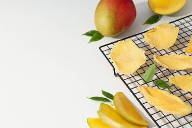 Kurutulmuş mango cipsi ve taze kesilmiş mango.