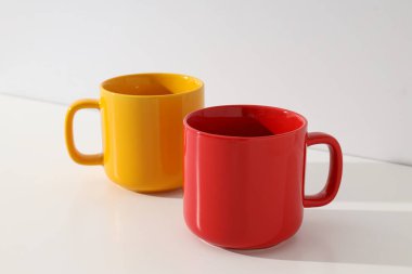 Red and yellow cups on a light background clipart