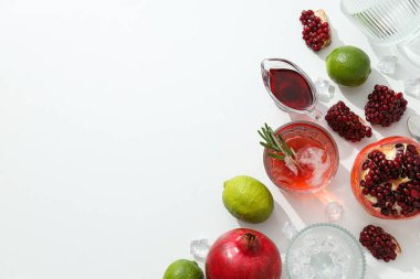 Beyaz arka planda taze nar ve limonlu kırmızı kokteyl.