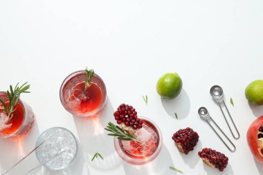 Beyaz arka planda taze nar ve limonlu kırmızı kokteyl.