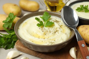 Kasede patates püresi, kaşık ve malzemeler gri arka planda, kapat.