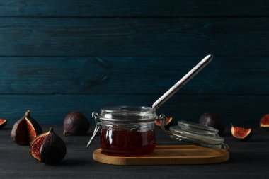 Mavi ahşap arka planda incir ve reçel kavanozu