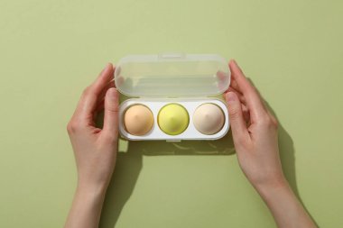 Plastik bir kutuda hafif arka planda makyaj süngerleri