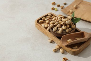 Ahşap bir tabakta, arka planda fıstıklar..