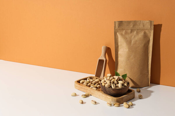 Pistachios in a craft bag, on a yellow background.