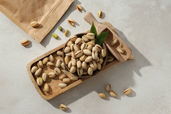 Pistachios in a craft bag, on a yellow background.