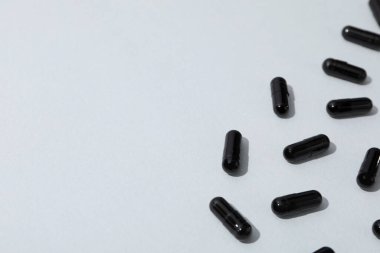 Activated carbon in the form of tablets, on a light background. clipart