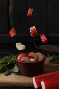 Koyu bir arka planda bir kasede kesilmiş ravent sapları.