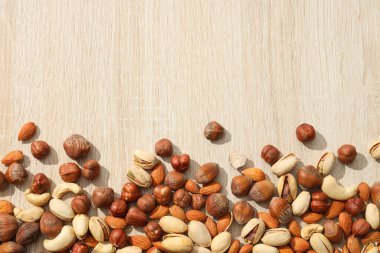 Tahta bir masanın üzerinde değişik fındıklar var.