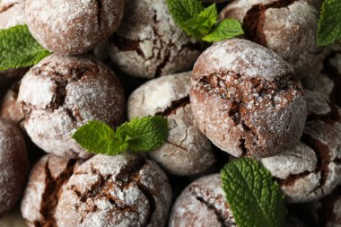 Appetizing crinkle cookies, on parchment, on a dark background.