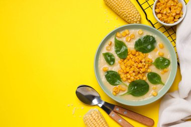 Sarı arka planda, tabakta mısır çorbası..