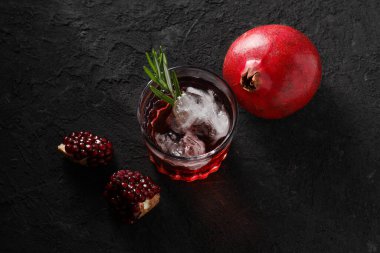 Koyu arkaplanda taze nar ve kırmızı kokteyl.