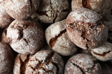 İştah açıcı buruşuk kurabiyeler, parşömen üzerinde, koyu bir arka planda..