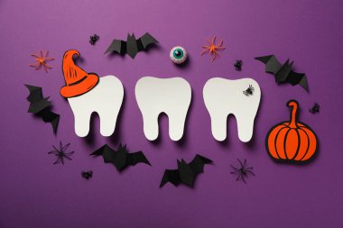 Cadılar Bayramı aksesuarlı büyük diş, renkli bir arka planda..