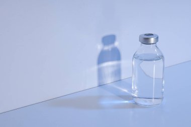 Hafif arka planda sıvı bulunan cam tıbbi şişe, metin için boşluk