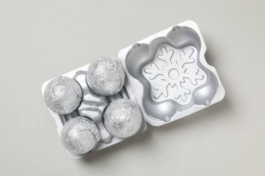 Açık gri arkaplanda gümüş çantalı folyo topları, üst görünüm