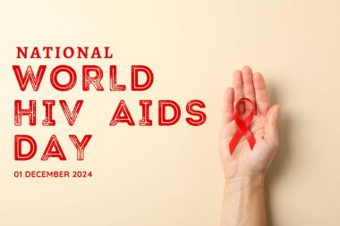 AIDS günü, kırmızı kurdele elinde açık arkaplanda metin manzaralı