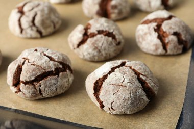 İştah açıcı buruşuk kurabiyeler, parşömen üzerinde, koyu bir arka planda..