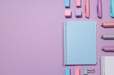 Menekşe arkaplanda kırtasiye malzemesi olan iki defter