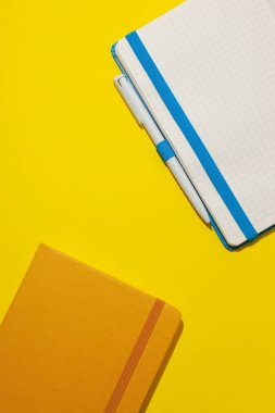 Sarı arka planda iki defter var.