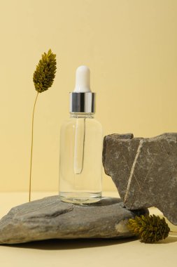 Kahverengi bir şişede çakıl taşıyla kozmetik yağı.