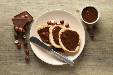 Tahta arka planda bir kasede çikolata ezmeli ekmek.