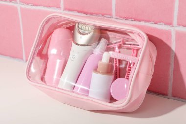 Pembe kozmetik torbalarda tüy dökücü aksesuarlar.