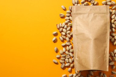 Sarı arka planda el çantasındaki fıstıklar..